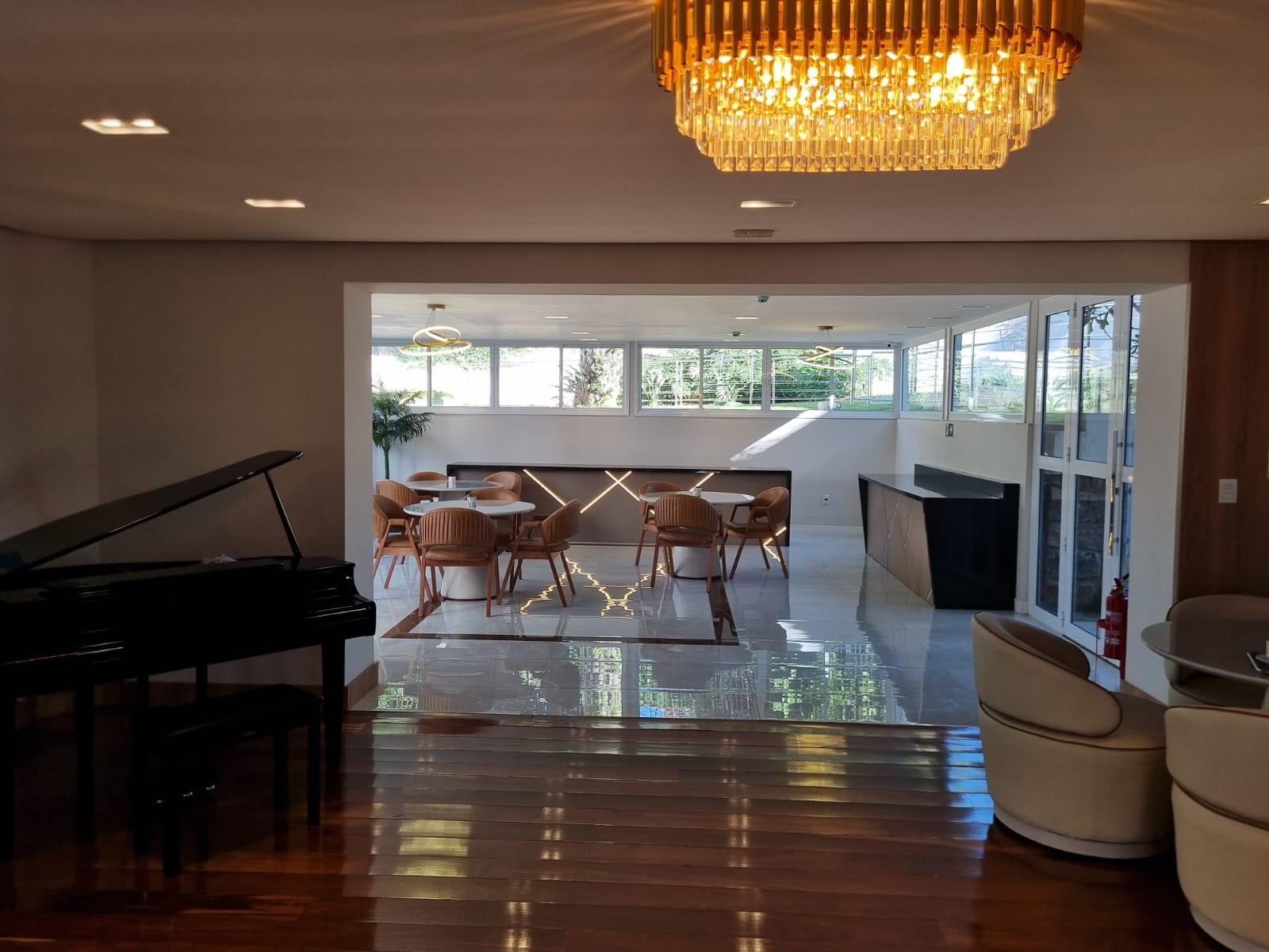 Hall com lustre de cristal e escadaria no Flat Care