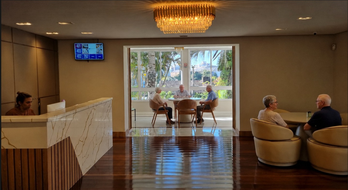 Sala de convívio com piano e poltronas no Flat Care